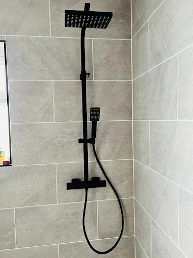 Matt black thermostatic shower fitted in a tiled bathroom